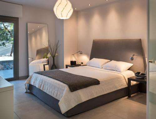 a bedroom with a large bed and a mirror at Villa Soligia Blue in Pefkali