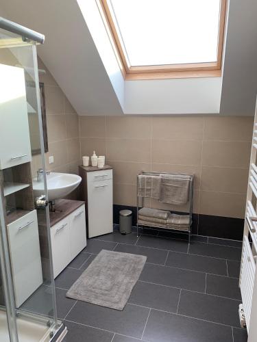 a bathroom with a sink and a skylight at Schöne und Helle Deutsch-Wagram Wohnungen in Deutsch-Wagram