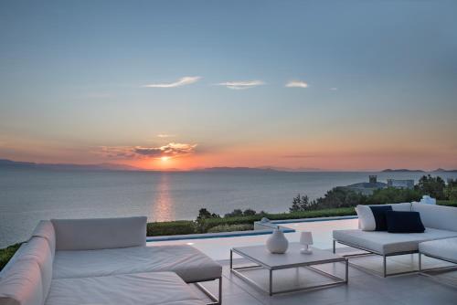 a living room with a couch and a view of the ocean at Villa Soligia Blue in Pefkali