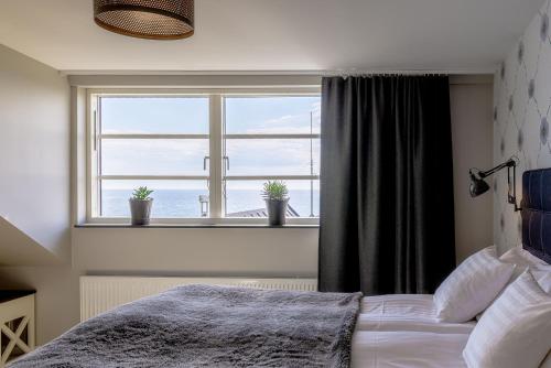 um quarto com uma cama e uma grande janela em Bongska Huset em Abbekås
