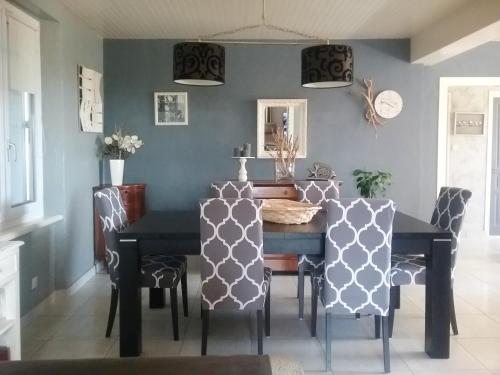 une salle à manger avec une table et des chaises noires dans l'établissement Maison cosy à Cléder avec jardin et vélos à disposition, à Cléder