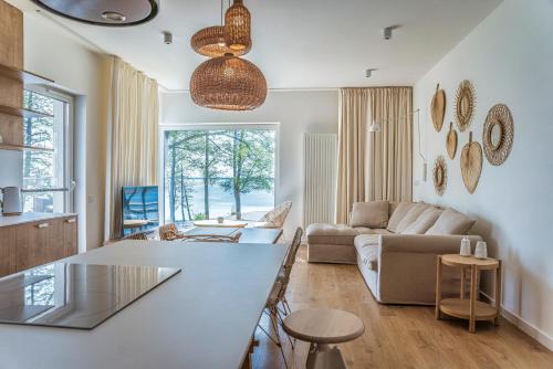 a living room with a table and a couch at Nautica Resort in Giżycko