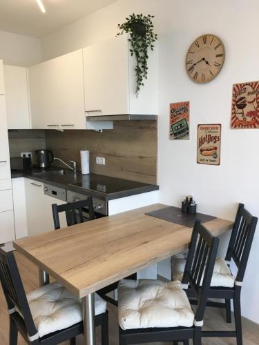 a kitchen with a wooden table and chairs and a clock at Schöne und Helle Deutsch-Wagram Wohnungen in Deutsch-Wagram