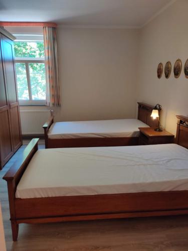 2 Betten in einem Zimmer mit Fenster und 2 Betten in der Unterkunft Hotel LG Wolfsburg in Wolfsburg
