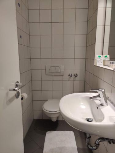 a bathroom with a sink and a toilet at Hotel LG Wolfsburg in Wolfsburg