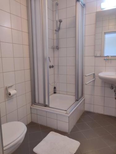 y baño con ducha, aseo y lavamanos. en Hotel LG Wolfsburg en Wolfsburg