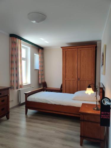 a bedroom with a bed and a dresser and a window at Hotel LG Wolfsburg in Wolfsburg