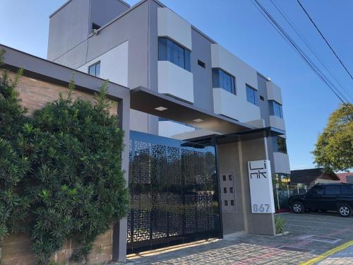 a white building with a gate in front of it at Link Araranguá in Araranguá