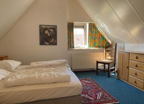 a bedroom with two beds and a dresser and a window at Hello Zeeland - Vakantiehuis Stern 188 in Breskens