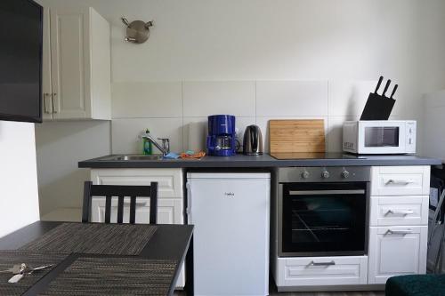 a kitchen with a stove and a microwave at FeWo Engler Wallstraße W1 in Lüneburg