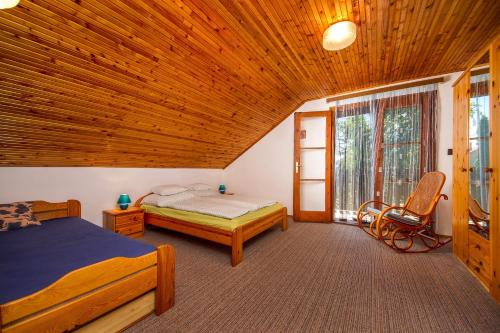 1 Schlafzimmer mit 2 Betten und Holzdecke in der Unterkunft Familia nyaraló 16 in Balatonmáriafürdő