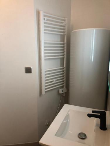 a bathroom with a sink and a refrigerator at Appartement centre historique Sancerre in Sancerre