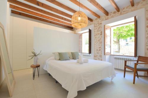 sypialnia z białym łóżkiem i oknem w obiekcie Sa Vicaria w mieście Santa Eugenia