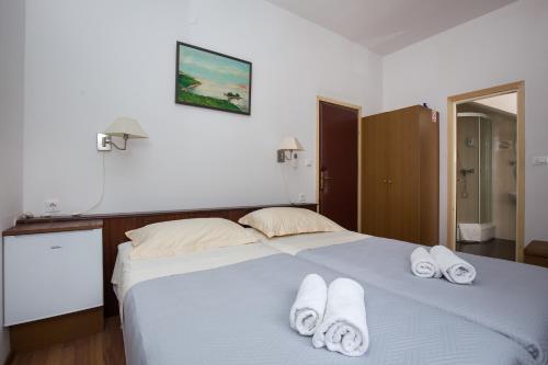 Un dormitorio con una cama con toallas blancas. en Villa Konalic, en Mokošica