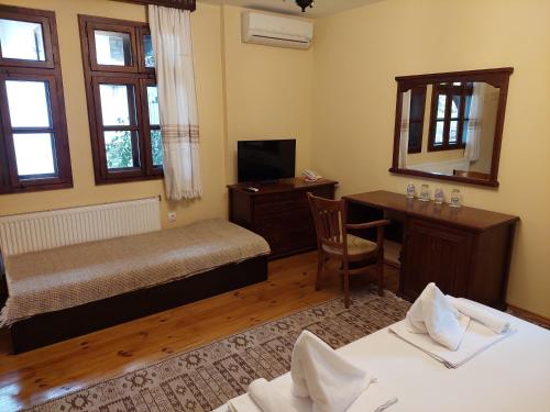 1 dormitorio con cama, escritorio y espejo en Guest Rooms Cheshmata, en Arbanasi