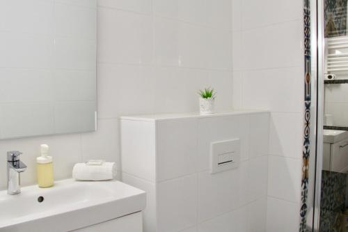 une salle de bain blanche avec un lavabo et un miroir dans l'établissement LE SERINITY - Studio 10 min des plages à pieds, wifi, parking, clim, à La Grande Motte