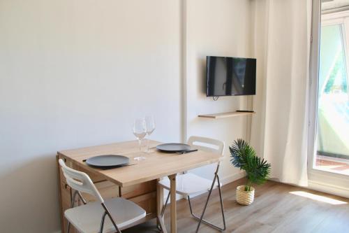 une table à manger avec deux chaises et une télévision dans l'établissement LE SERINITY - Studio 10 min des plages à pieds, wifi, parking, clim, à La Grande Motte