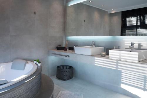 a bathroom with two sinks and a tub at Villa Soligia Blue in Pefkali