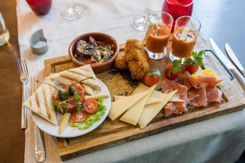 a tray of food with meats and cheese on a table at Villmergen Swiss Quality Hotel in Villmergen