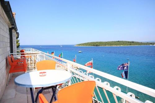 a balcony with a table and chairs and the water at Guesthouse Gradina in Lovište