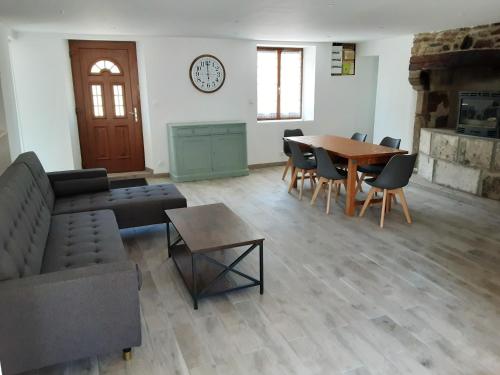sala de estar con sofá, mesa y sillas en Maison de 3 chambres avec jardin clos et wifi a Quettehou, en Quettehou