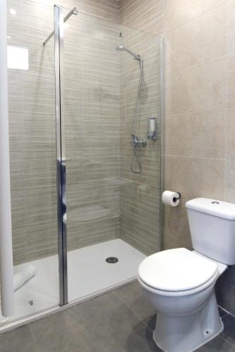 a bathroom with a toilet and a glass shower at Hotel BESTPRICE Alcalá in Madrid