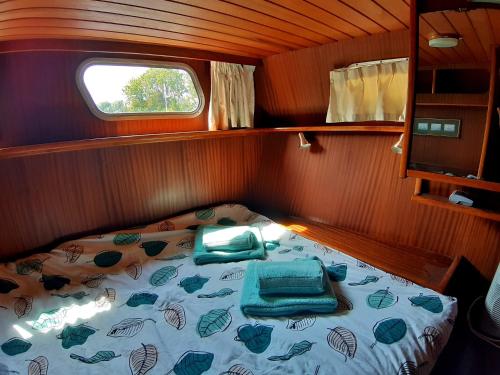 a bed in the back of a small boat at Motor Yacht Amstelle in Amsterdam