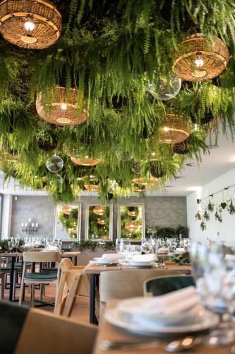 a dining room with tables and chairs and chandeliers at HERBARIUM boutique hotel in Olomouc