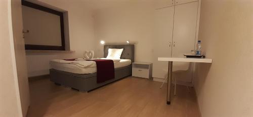 a small bedroom with a bed and a table at WILLA BAJLAND in Warsaw