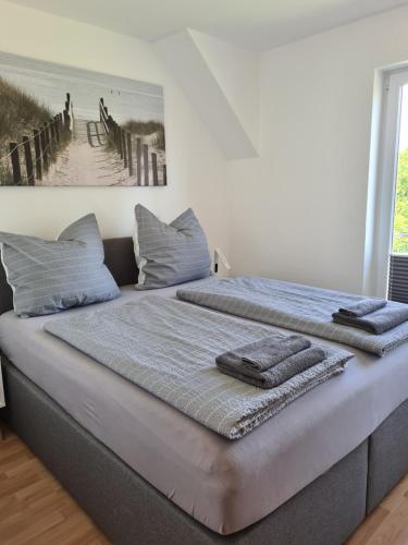 een bed met twee handdoeken in een kamer bij Haus Annelie FEWO 2 OG in Dranske