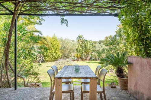 a wooden table and chairs in a garden at Casa Arco in Costitx