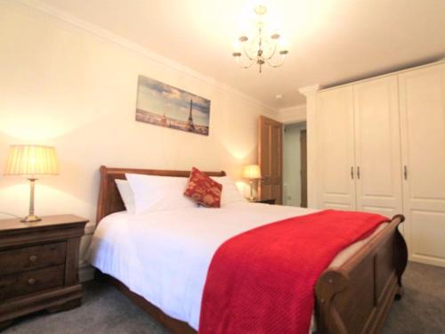 a bedroom with a large bed with a red blanket at The Post House in Kinsale