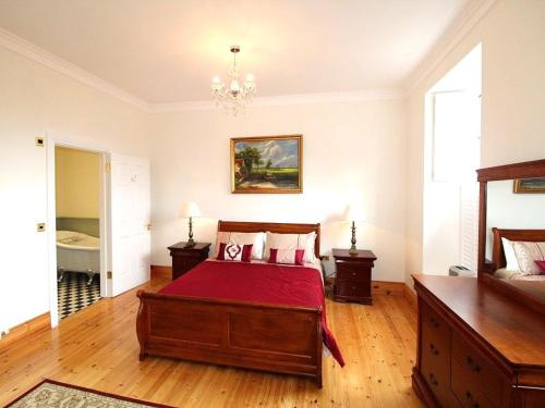 a bedroom with a bed and a chandelier at The Post House in Kinsale