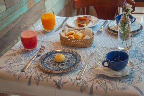 a table with plates of food and drinks on it at Pousada Villa Aurora in Serra Negra