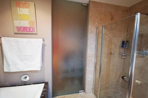 a shower with a glass door in a bathroom at 1507-Amazing views & Unique Joburg CBD Luxury in Johannesburg