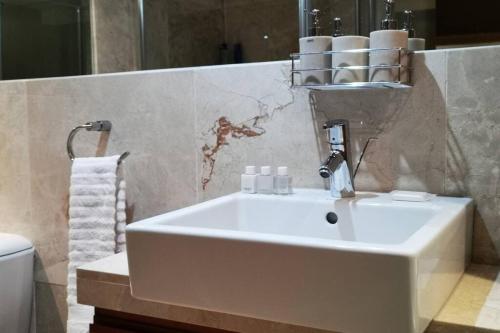 a bathroom with a white sink and a toilet at 1507-Amazing views & Unique Joburg CBD Luxury in Johannesburg