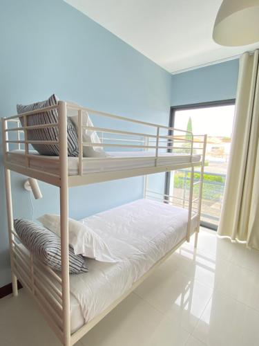 a bunk bed in a room with a window at Bordal Houses Casa da Areia in Porto Santo