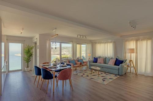 a living room with a couch and a table and chairs at SeaSimbra Apartment in Sesimbra
