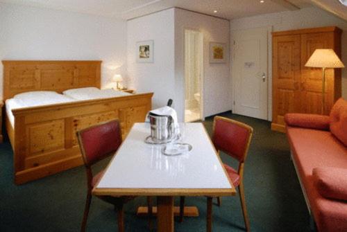 Zimmer mit einem Tisch, Stühlen und einem Bett in der Unterkunft Hotel Churfirsten in Walenstadt