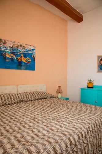 a bedroom with a bed and a painting on the wall at Tal-Karmnu Entire house with private heated pool and jacuzzi in Kirkop