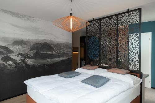 a bedroom with a bed and a painting on the wall at Boutique Hotel Stanserhof in Stans