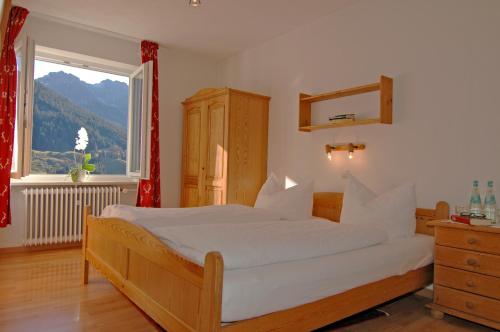 um quarto com uma cama grande e uma janela grande em Ferienhaus Ahorn em Mittelberg