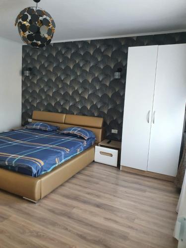 a bedroom with a bed with a blue comforter at Apartament Radu in Călimăneşti