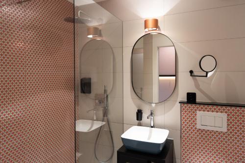 a bathroom with a sink and a mirror at Boutique Hotel Stanserhof in Stans