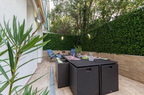 尼斯的住宿－Comfort and style 2 BR AC & Large Patio Near Sea，庭院配有桌椅和树 ⁇ 。