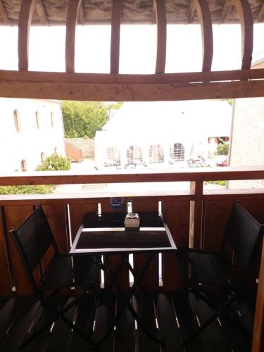 une table et des chaises dans une pièce avec une fenêtre dans l'établissement Le Petit Clos, à Commes