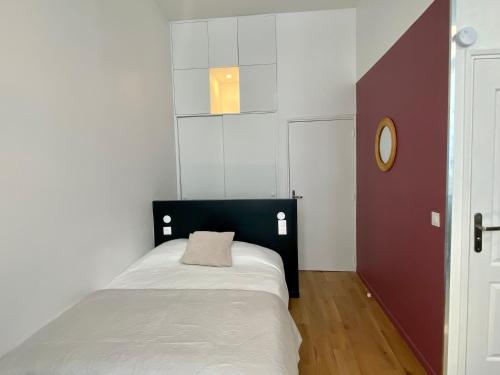 a small bedroom with a bed and a mirror at Studio Aboukir 2 in Paris