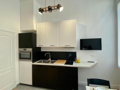 una cocina con armarios blancos y fregadero en Studio Aboukir 2 en París