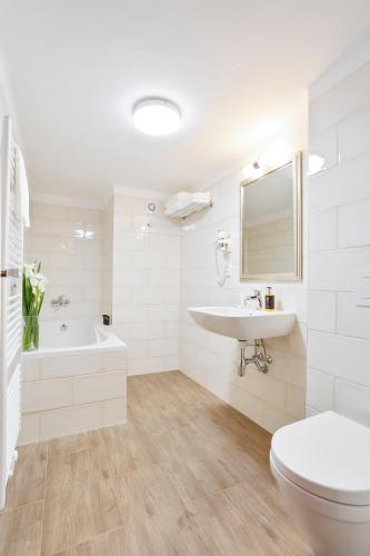 a bathroom with a tub and a sink and a toilet at Zámecký hotel & Wellness in Poděbrady