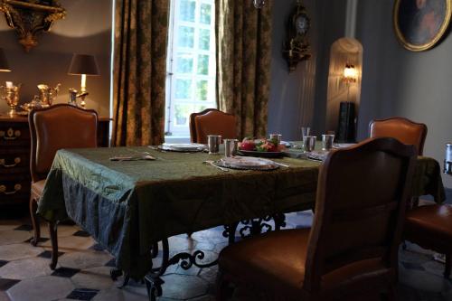 comedor con mesa, sillas y ventana en Château de Trébons en Grainville-Ymauville